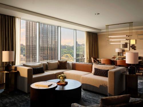 a living room with a couch and a large window at Fairmont Pittsburgh in Pittsburgh