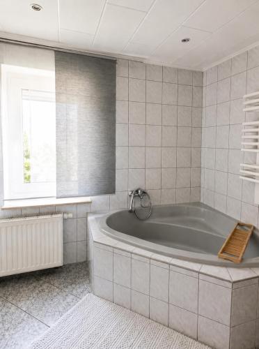 a bath tub in a bathroom with a window at Ferienwohnung AM PETER in Gotha