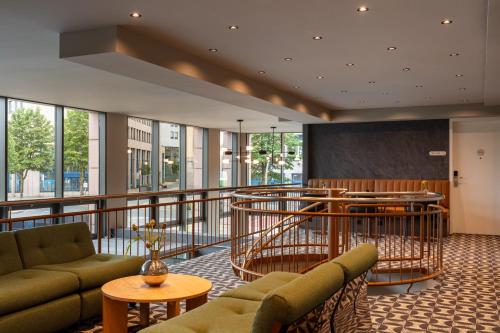 a lobby with couches and a bar in a building at Bob W Dortmund Stadtmitte in Dortmund