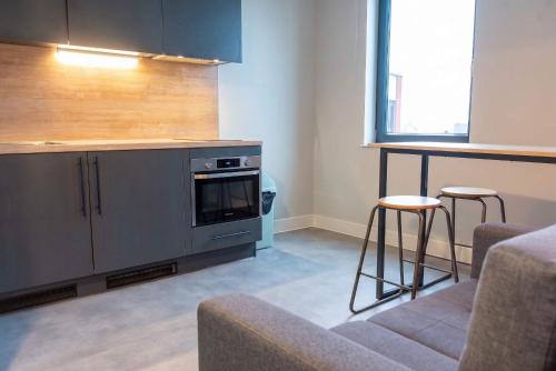 a kitchen with a stove and two bar stools at Student Only Studio in Central Loughborough in Loughborough