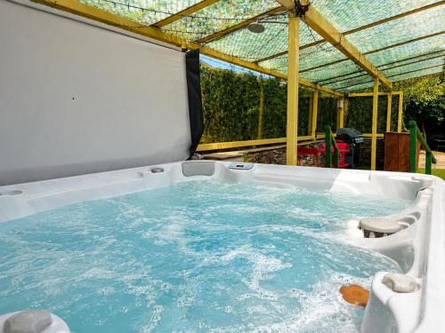 a hot tub in a backyard with a pergola at Howgills Barn in Sedbergh