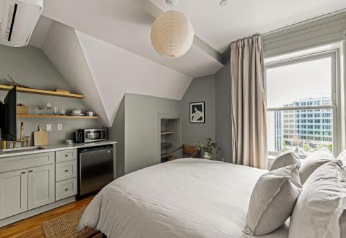 a bedroom with a bed and a kitchen with a window at Suite 5B at Maison Dupont a Dupont Circle Inn in Washington, D.C.