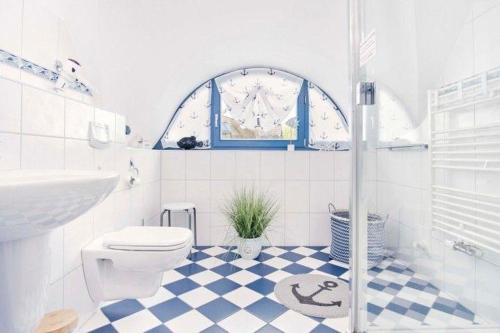 a white bathroom with a toilet and a sink at Ferienhaus-Seehund in Glowe