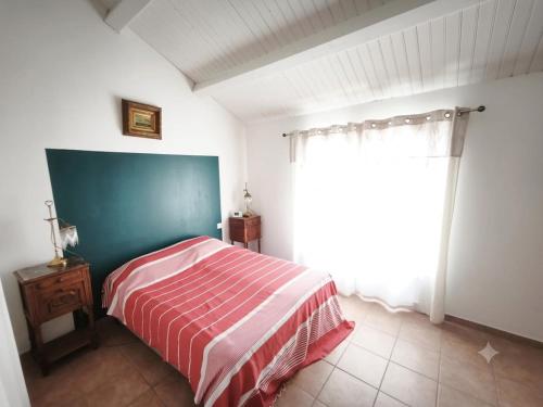 a bedroom with a bed and a large window at Sur les dunes in La Guérinière
