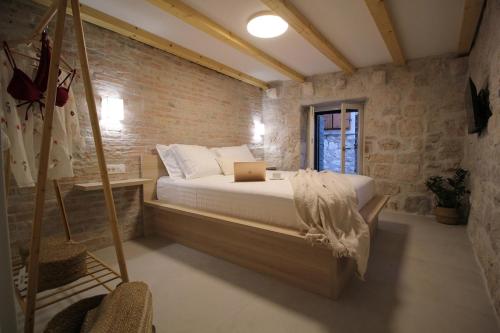 a bedroom with a bed with a laptop on it at Almara stone house - Authentic stone house in Vis in Vis
