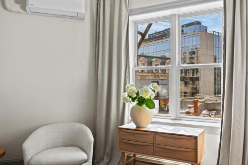 a vase of flowers on a table next to a window at Suite 4C at Maison Dupont a Dupont Circle Inn in Washington, D.C.