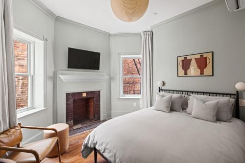 a white bedroom with a bed and a fireplace at Suite 3B at Maison Dupont a Dupont Circle Inn in Washington, D.C.