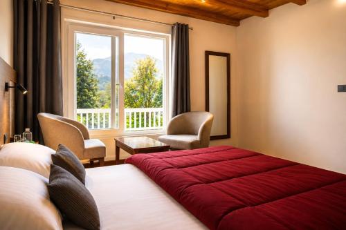 a bedroom with a red bed and a window at The Oak Lake Cottage Boho in Nainital