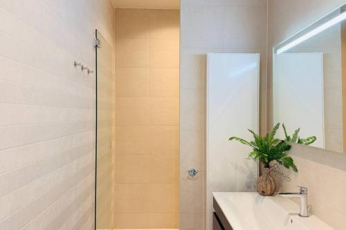 a bathroom with a sink and a shower with a mirror at Cooth's Prestige at the Square in Breda