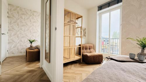 a bedroom with a bed and a large window at Cooth's Prestige at the Square in Breda