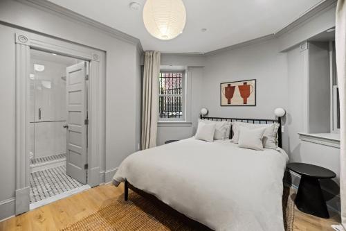 a bedroom with a white bed and a walk in shower at Suite 1B at Maison Dupont a Dupont Circle Inn in Washington, D.C.