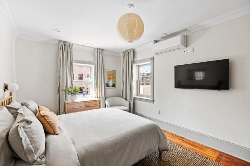 a bedroom with a bed and a flat screen tv at Suite 5C at Maison Dupont a Dupont Circle Inn in Washington, D.C.