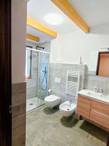 a bathroom with a toilet and a sink and a shower at Residence Moulin in Aymavilles