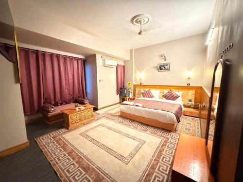 a hotel room with a bed and a rug at Hotel Pelri in Phuntsholing