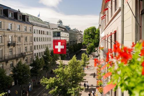 a view of a city street with a red cross sign at Hotel St.Gotthard in Zurich