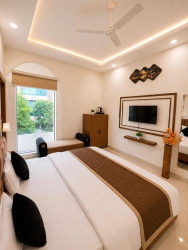 a bedroom with a large bed and a flat screen tv at Megh hotel in Gangānagar