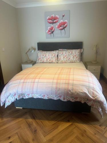 a bedroom with a bed with pink flowers on it at The River Nook in Termonbarry