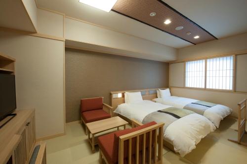 a room with two beds and a tv in it at Onyado Nono Sakaiminato Natural Hot Spring in Sakaiminato