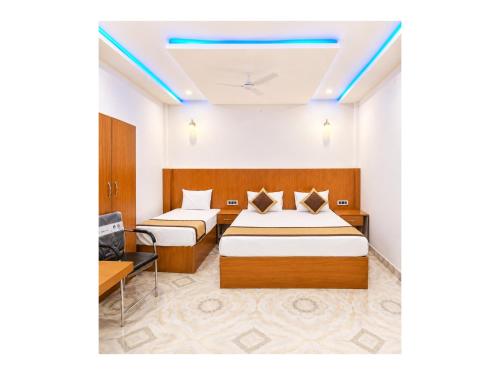 a hotel room with two beds and a tv at निर्मला पैलेस अयोध्या राम मंदिर - Hotel The New Nirmala Palace Ayodhya Near-Ram-Janmabhoomi-and-Ayodhya-Ram-Mandir-with-parking-and-Restaurant-Facilities - Best Hotel In Ayodhya in Ayodhya