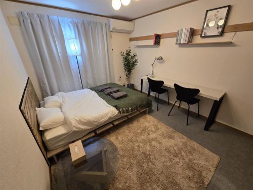 a bedroom with a bed and a table and chairs at Karawaru Stay 浦安 B303 Disney 9min in Tokyo