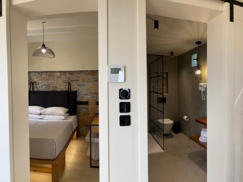 a bedroom with a bed and a bathroom at TERPOU StoneHouse & Suites in Volos