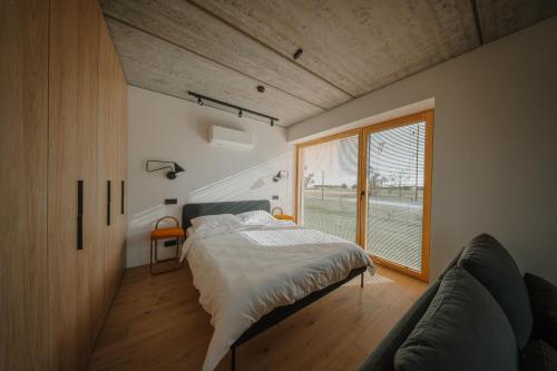 a bedroom with a bed and a large window at SVENCELE DUNES Marių g 31-1 in Svencelė