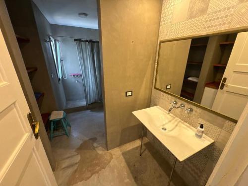 a bathroom with a sink and a mirror at Casa Benito - Barrio Privado con Piscina en Chapadmalal in Mar del Plata