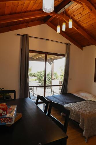 a room with a bed and a table with a view at Orr Halevana in Bruchim Qela' Alon