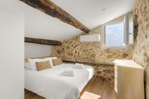 a bedroom with a white bed with a window at apt hospital in Tourrettes-sur-Loup