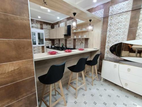 a kitchen with a bar with stools in it at Villa skikda in Skikda