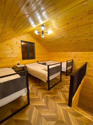 a room with two beds in a wooden cabin at Барнхаус in Bosteri