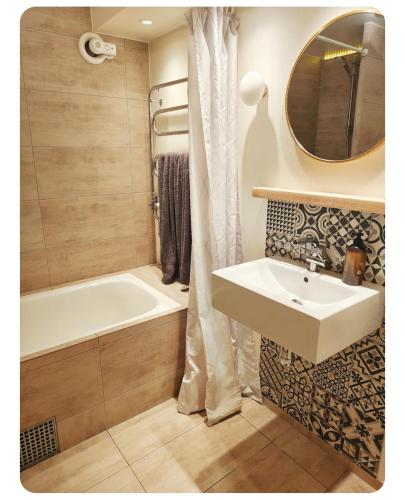 a bathroom with a sink and a tub and a mirror at Villan Lyan in Lund