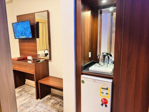 a small bathroom with a sink and a refrigerator at فندق الريادة جراند in Mecca