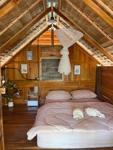 a bedroom with a large bed in a attic at Khao Phang Camping in Ban Pha Saeng Lang