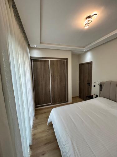 a bedroom with a white bed and a window at Nakhla in Dar Bouazza