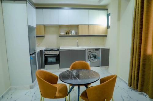 a kitchen with a table and chairs and a kitchen with a dishwasher at Star home Tower in Mogadishu