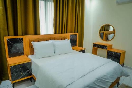 a bedroom with a large white bed and a mirror at Star home Tower in Mogadishu