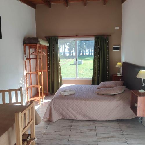 a bedroom with a bed and a large window at Complejos EG in San Miguel del Monte