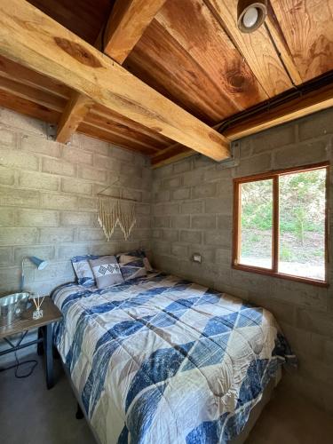 a bedroom with a bed and a wooden ceiling at Quinta Las Hortensias in Monte San Juan