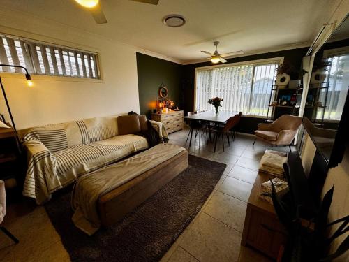 a living room with a couch and a table at Maitland Getaway - Spa, EV Friendly, Pet Friendly in Telarah
