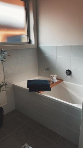 a bathroom with a bath tub with a towel on it at Maitland Getaway - Spa, EV Friendly, Pet Friendly in Telarah