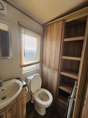 a small bathroom with a toilet and a sink at A21 Unity Beach, Brean in Brean