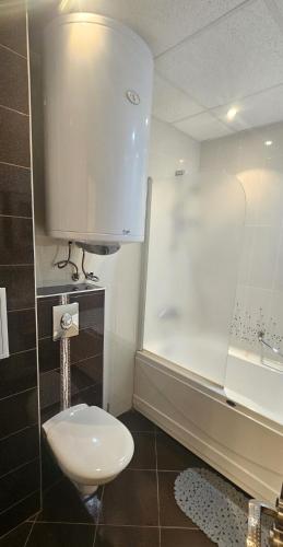 a bathroom with a toilet and a sink and a shower at Sun Sea 3 sea view in Shkorpilovtsi