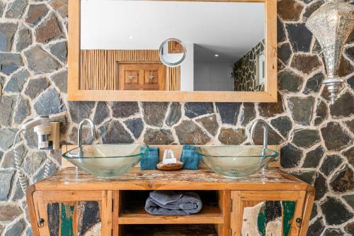 a bathroom with two bowls on a wooden table with a mirror at Bamboo Bonaire by Boutique Bonaire Unique Resorts in Kralendijk