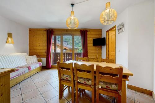 a living room with a table and chairs and a bedroom at Les Ancolies Benelli in Les Menuires