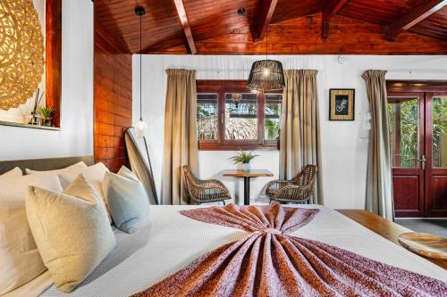 a bedroom with a large bed and a table at Bamboo Bonaire by Boutique Bonaire Unique Resorts in Kralendijk