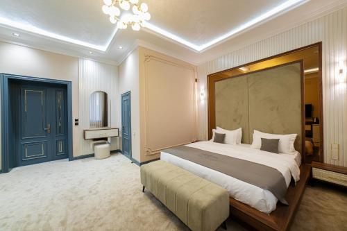 a large bedroom with a large bed and a chandelier at Istanbul Palace Hotel in Urganch