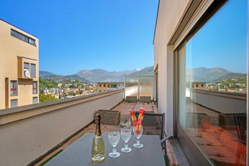 a table with wine bottles and glasses on a balcony at BoReal Apartments in Paradiso