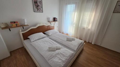 a bedroom with a bed with two pillows on it at Apartmani Rama - terra nostra in Prozor