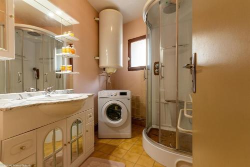 a bathroom with a sink and a washing machine at Georgeluc in Langeron